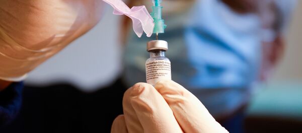 Вакцину против COVID-19 Pfizer-Biontech медик набирает в шприц - Sputnik Литва