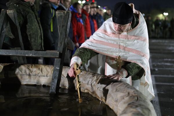 Настоятель, отец Михаил Францев, освящает воду перед началом крещенских купаний  в Новороссийске - Sputnik Литва