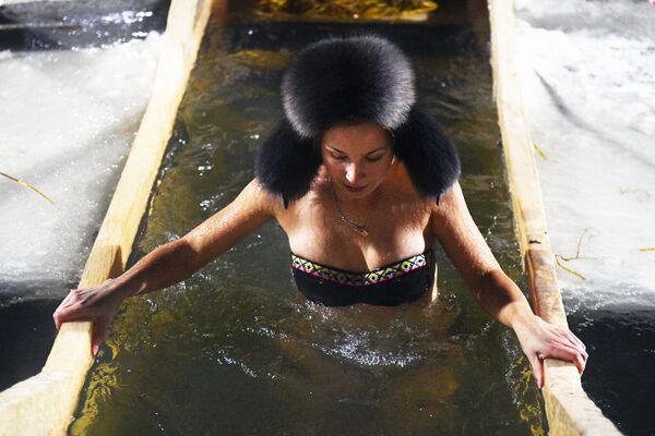 Девушка во время крещенского купания в проруби на реке Обь в черте Новосибирска - Sputnik Литва