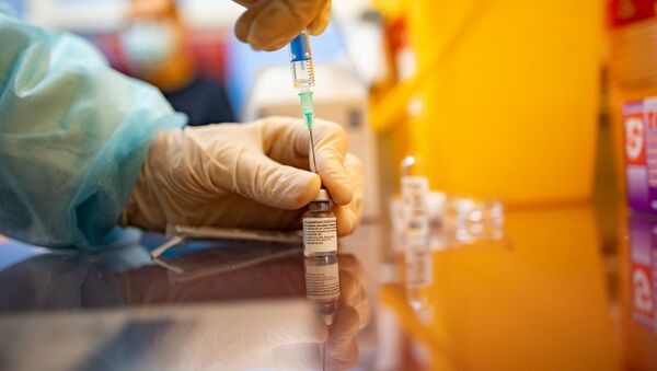 Вакцину против COVID-19 Pfizer-Biontech медик набирает в шприц - Sputnik Литва