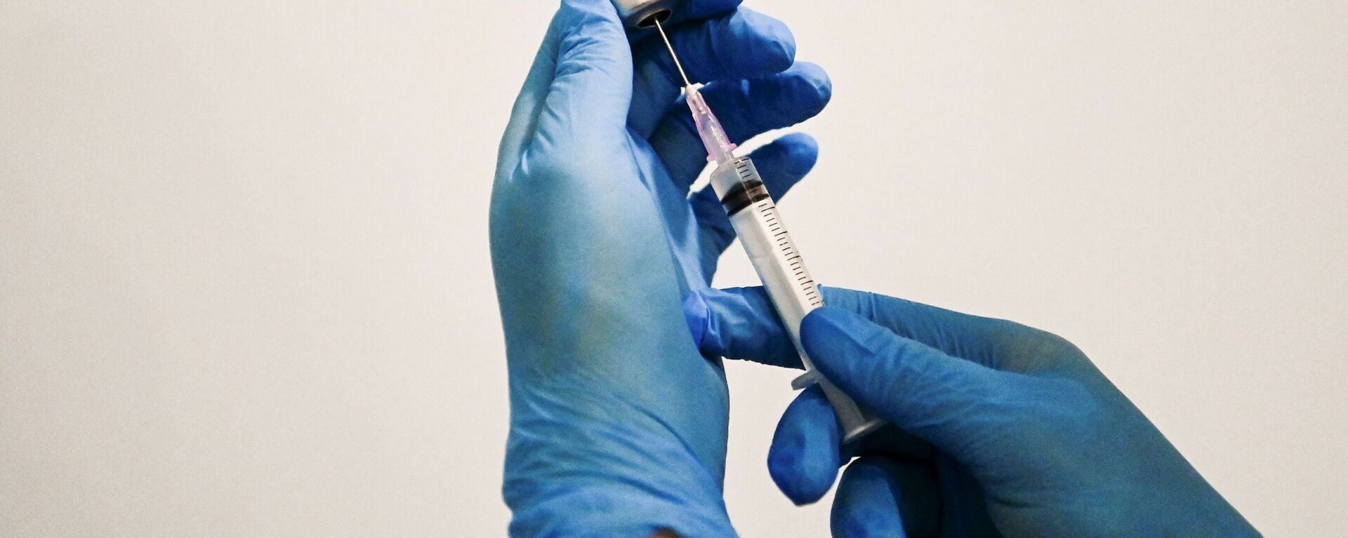 Медицинский сотрудник держит в руках вакцину Спутник V в пункте вакцинации - Sputnik Lietuva, 1920, 14.05.2021
