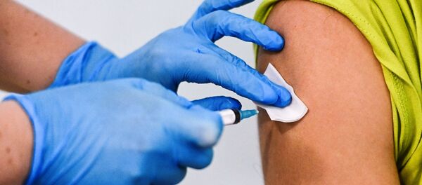 Девушке делают прививку от коронавируса в пункте вакцинации - Sputnik Литва