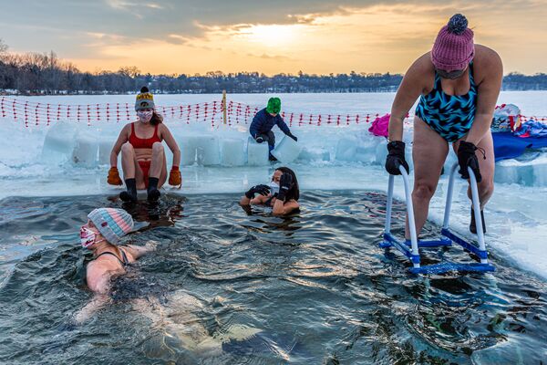 Члены американской группы любителей зимнего плавания Submergents во время купания в проруби на озере Харриет в Миннеаполисе, штат Миннесота - Sputnik Lietuva