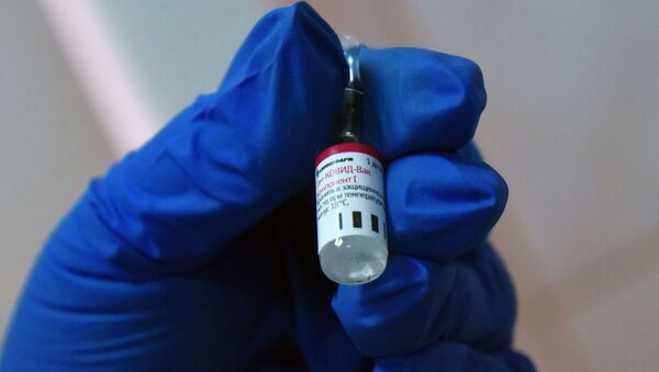 Медицинский работник держит в руке вакцину от COVID-19 Спутник-V (Гам-КОВИД-Вак) - Sputnik Литва
