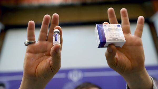 Медик держит ампулу и упаковку с вакциной против COVID-19 Спутник V (Гам-КОВИД-Вак) - Sputnik Литва