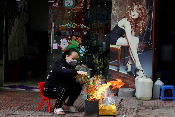 Женщина сжигает копию денежных банкнот в рамках празднования Нового года по лунному календарю, Вьетнам - Sputnik Lietuva
