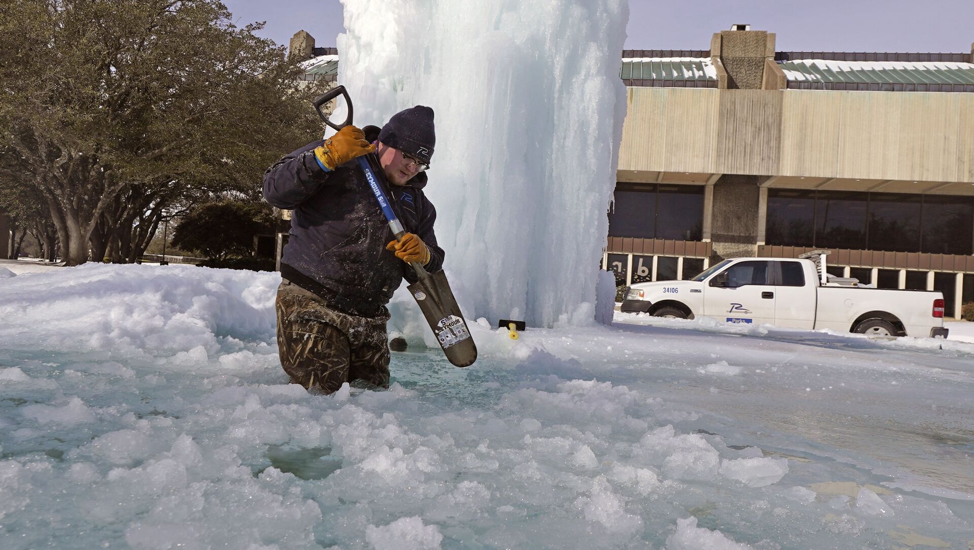 Рабочий ломает лед в замерзшем фонтане в Ричардсоне, штат Техас, США - Sputnik Литва, 1920, 23.02.2021