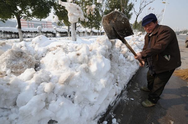 Китайский рабочий чистит улицы от сильного снегопада в Китае, 2008 год  - Sputnik Литва