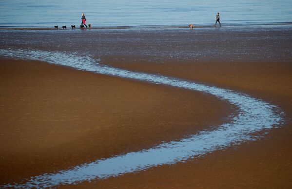 Люди гуляют по пляжу в Британии - Sputnik Lietuva