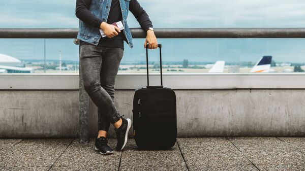 Мужчина с чемоданом в аэропорту - Sputnik Lietuva