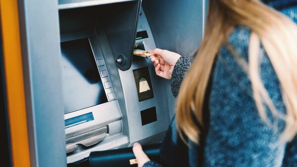 Девушка пользуется банкоматом, архивное фото - Sputnik Литва