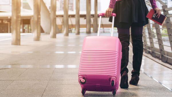 Девушка с чемоданом в зале ожидания аэропорта - Sputnik Литва