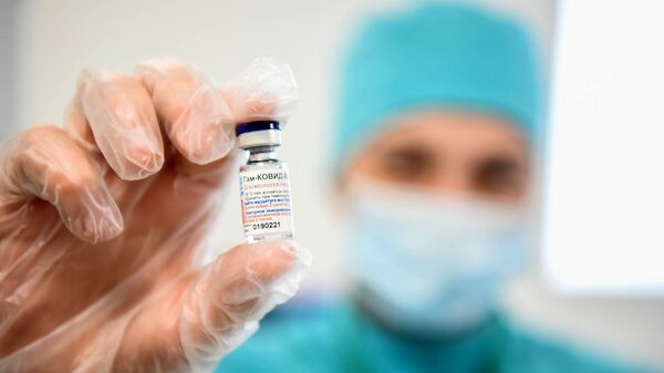 Медик держит ампулу с вакциной Спутник-V (Гам-КОВИД-Вак) - Sputnik Литва