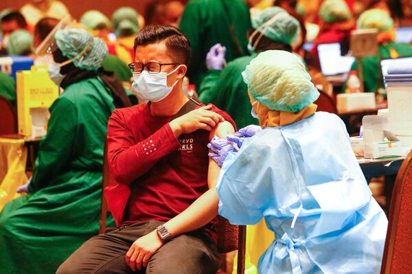 Vyras gauna pirmąją vakciną nuo COVID-19, Indonezija - Sputnik Lietuva