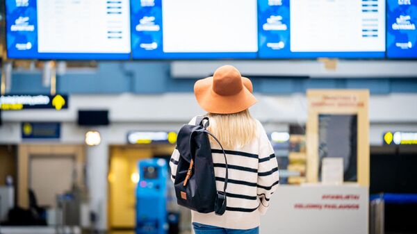 Девушка смотрит на информационное табло в аэропорту Вильнюса - Sputnik Литва