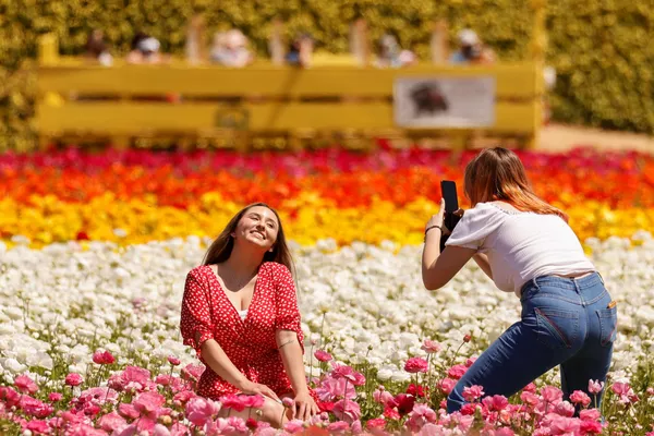 Посетители фотографируются на поле лютиков в Калифорнии 