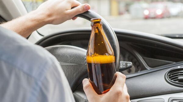 Водитель с бутылкой алкоголя за рулем, архивное фото - Sputnik Литва