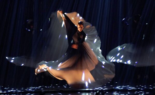 Nuotraukoje: moteris atlieka flamenko šokį. Flamenko suknelės paprastai būna iki grindų, dažnai pasiūtos iš įvairiaspalvio taškuoto audinio, dekoruotos raukiniais. - Sputnik Lietuva