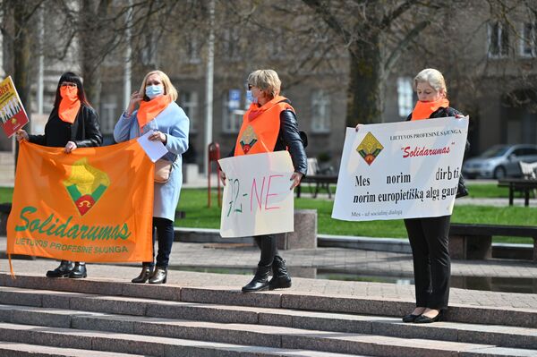 Девушка справа держит плакат с лозунгом: Мы хотим работать, хотим получать европейскую зарплату. - Sputnik Литва