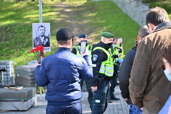 Nors oficialiai šiais metais dėl karantino apribojimų Nemirtingojo pulko eisena Antakalnio karių kapinėse buvo atšaukta, vis dėlto daugelis atsinešė savo žuvusių artimųjų nuotraukas. - Sputnik Lietuva