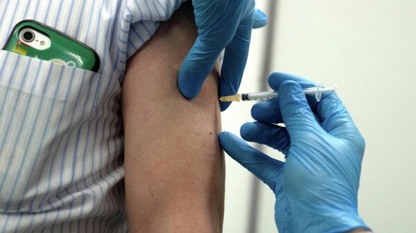 Медработник делает прививку от коронавируса вакциной Moderna - Sputnik Литва