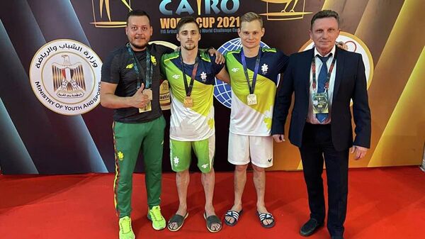 Литовские гимнасты Роберт Творогал (второй слева) и Томас Кузмицкас (третий) на ЧМ по спортивной гимнастике в Каире - Sputnik Литва