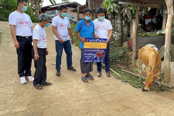 Charanas Damrongkiatpana laiko ženklą (po to, kai laimėjo skiepytų gyventojų loterijos kampaniją, per kurią laimėjo gyvą karvę), siekdamas paskatinti vietinį skiepijimą nuo koronaviruso Chiang Mai provincijoje, Tailande, 2021 metų birželio 8 dieną. - Sputnik Lietuva