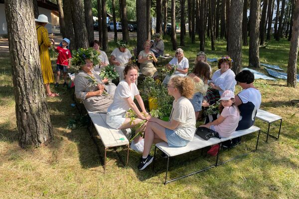 Соблюдая традицию праздника, девушки сели плести венки под традиционный песни, которые исполняли хором. - Sputnik Литва