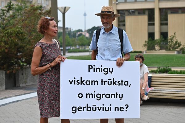 Užrašas ant plakato: &quot;Pinigų viskam trūksta, o migrantų gerbūviui ne?&quot;. - Sputnik Lietuva