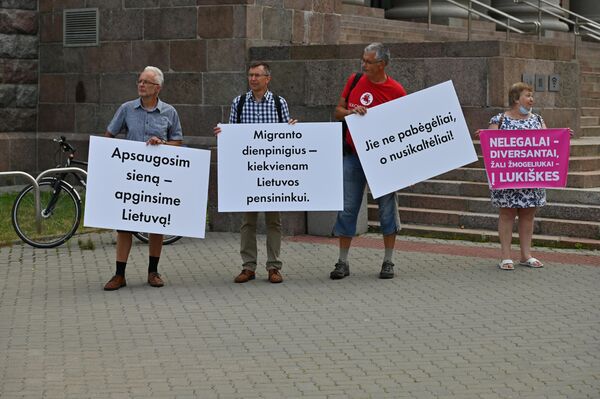 Užrašai ant plakatų: &quot;Apsaugosim sieną – apsaugosime Lietuvą!&quot;, &quot;Migranto dienpinigius –kiekvienam Lietuvos pensininkui&quot;, &quot;Jie ne pabėgėliai, o nusikaltėliai!&quot;, &quot;Nelegalai diversantai, žali žmogeliukai – į Lukiškes&quot;. - Sputnik Lietuva