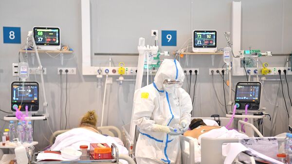 Медицинский работник в палате реанимации и интенсивной терапии во временном госпитале для больных COVID-19 - Sputnik Литва