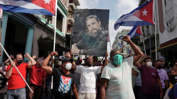 Сторонники правительства держат фотографию покойного президента Кубы Фиделя Кастро во время акций протеста в Гаване - Sputnik Lietuva