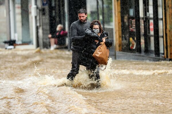 Vyras padeda moteriai eiti užlieta gatve Spa mieste, Belgijoje. - Sputnik Lietuva