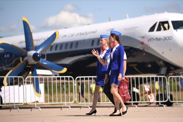 Stiuardesės keleivinio lėktuvo &quot;Il-114-300&quot; fone Tarptautinėje aviacijos ir kosmoso parodoje &quot;MAKS-2021&quot;. - Sputnik Lietuva