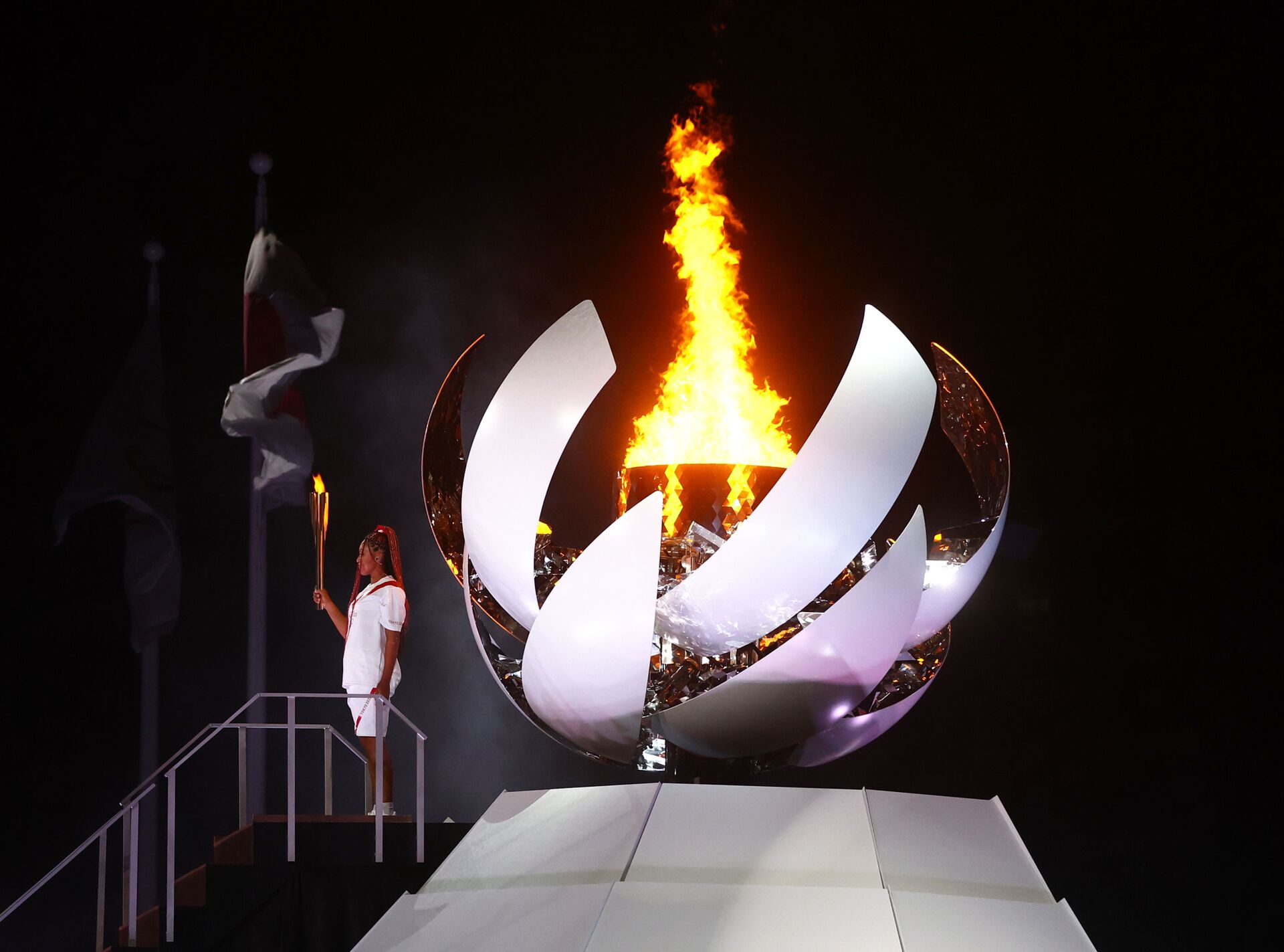 Наоми Осака из Японии держит олимпийский факел после зажжения олимпийского котла на церемонии открытия  - Sputnik Литва, 1920, 24.07.2021