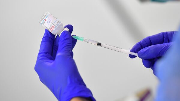 Медсестра готовит дозу вакцины Moderna от коронавируса - Sputnik Литва
