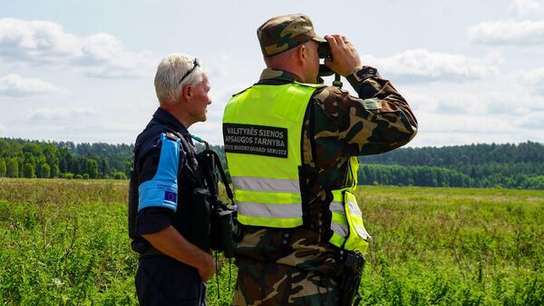 Литовский пограничник и сотрудник агентства Евросоюза по безопасности внешних границ Frontex (Фронтекс) на границе Литвы и Белоруссии - Sputnik Литва