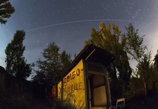 Šioje ilgos ekspozicijos nuotraukoje, padarytoje su žuvies akies lęšiu, Tarptautinė kosminė stotis (TKS) juda palei savo orbitą virš oro reidų prieglaudos įėjimo su užrašu &quot;Bombų prieglauda&quot; šone, kur žmonės slepiasi nuo naktinio apšaudymo, Petrovskio rajone, Donecke, Rytų Ukraina, vėlai pirmadienį, 2014 metų rugpjūčio 4 diena. - Sputnik Lietuva