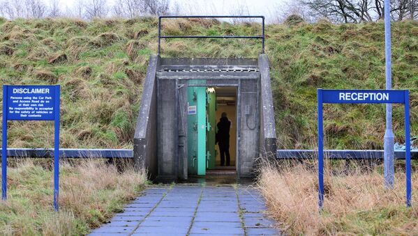 Nuotraukoje pavaizduotos dvigubos sprogimo durys prie pagrindinio įėjimo į branduolinį bunkerį Ballymena pakraštyje Šiaurės Airijoje 2016 m. Vasario 4 d., Priklausančios Pirmojo ir Pirmojo viceministro kanceliarijai ir pateiktos pardavimui. -Bunkeris pradėtas statyti 1987 metais. Stipriai įtvirtinta požeminė pastogė buvo suprojektuota priimti 235 VIP asmenis, joje yra bendrabučiai, virtuvės patalpos ir nukenksminimo kameros. Tikimasi, kad parduodant bunkerį bus parduota daugiau nei pusė milijono svarų sterlingų. - Sputnik Lietuva