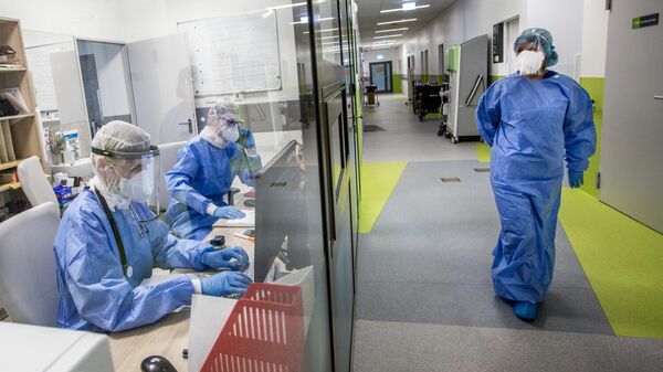 Медработники в защитных костюмах в Вильнюсской университетской клинической больнице Сантарос - Sputnik Литва