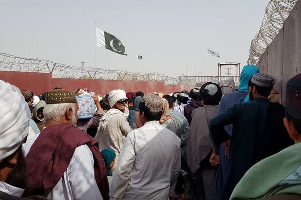 Pakistano ir Talibano vėliava, kai žmonės eina į Afganistaną Draugystės perėjimo punkte Pakistano ir Afganistano pasienio mieste Čamane. - Sputnik Lietuva