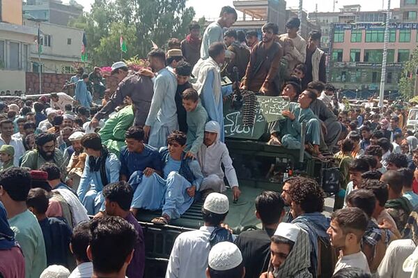 Talibano kovotojai ir vietiniai žmonės ant Afganistano nacionalinės armijos (ANA) &quot;Humvee&quot; transporto priemonės Džalalabado provincijos gatvėje. - Sputnik Lietuva