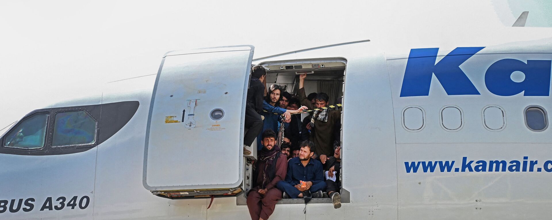 Афганцы сидят в дверях самолета в аэропорту Кабула - Sputnik Литва, 1920, 20.08.2021