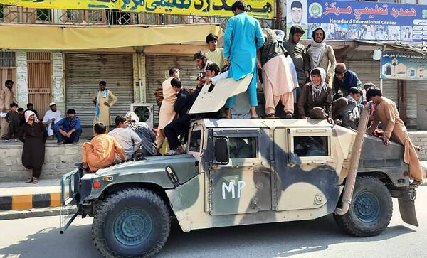 2021 metų rugpjūčio 15 dieną Talibano kovotojai ir vietos gyventojai sėdi ant Afganistano nacionalinės armijos (ANA) transporto priemonės pakelėje, Lagmano provincijoje. - Sputnik Lietuva