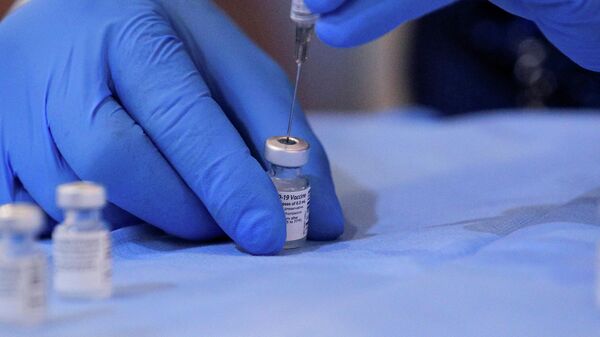 Медицинский работник готовит дозу вакцины Pfizer/BioNTech от коронавируса - Sputnik Литва