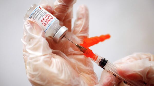 Медицинский работник готовит дозу вакцины Moderna от коронавируса - Sputnik Литва