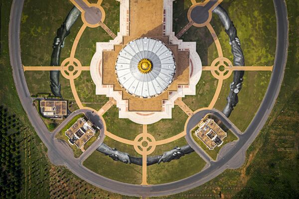Šioje nuotraukoje prancūzų-šveicarų menininkas kuria šešių  paveikslų kolekciją priešais Jamusukro Taikos Mergelės baziliką, Dramblio Kaulo Krante. Bendras paveikslo plotas sudaro 18 000 kvadratinių metrų, iš kurių 12 500 kvadratinių metrų yra visiškai nudažyti. - Sputnik Lietuva
