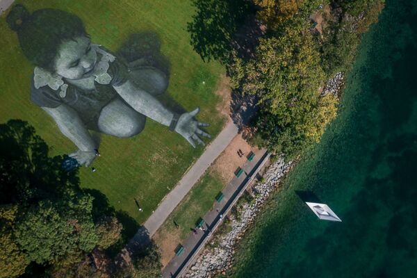 Šioje nuotraukoje iš oro užfiksuota prancūzų menininko Saype milžiniška freska, vaizduojanti mažą mergaitę, numetančią iš popieriaus sulankstyta valtį į Ženevos ežerą. Milžiniška 5000 kvadratinių metrų freska buvo pagaminta naudojant biologiškai suyrančius dažus, pagamintus iš natūralių pigmentų. - Sputnik Lietuva