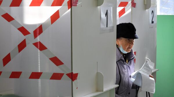 Пожилая женщина во время голосования на избирательном участке № 3381 в Москве - Sputnik Литва