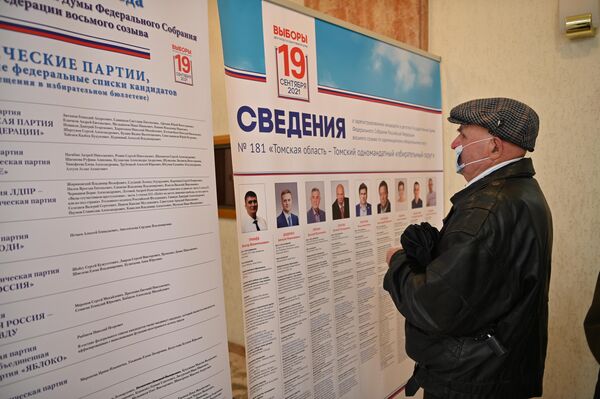 Nuotraukoje: rinkėjas Vilniaus apylinkėje apžiūri kandidatų į Rusijos Federacijos Valstybės Dūmą sąrašą. - Sputnik Lietuva